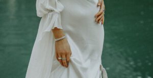 An up close shot of a bride touching her silky wedding dress