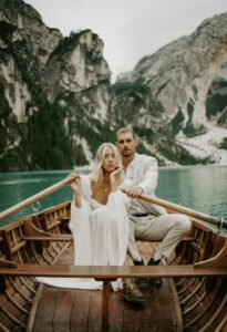 A bride and groom sit in a canoe at Lago Di Braies during their elopement