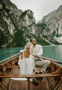 A bride and groom sit in a canoe at Lago Di Braies during their elopement
