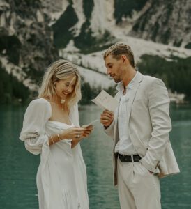 An elopement couple reads vows to each other at Lago Di Braies in the Italian Dolomites