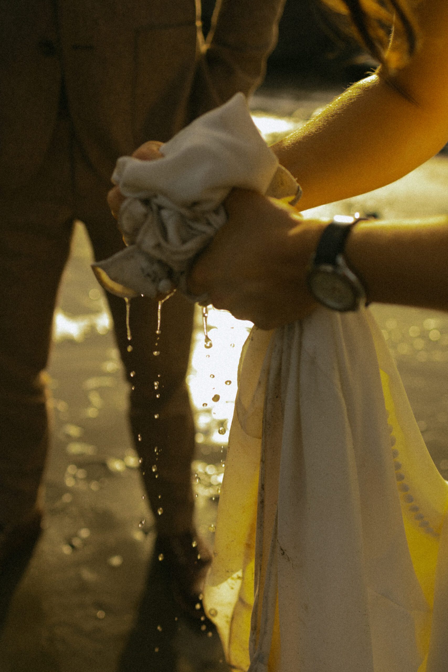 A bride wrings about her wedding dress of ocean water on the oregon coast