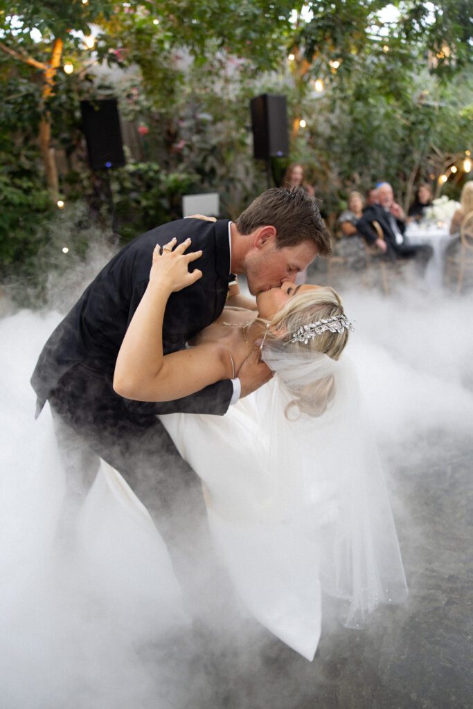 Bride and groom sharing a romantic first dance at La Caille wedding venue in Utah, surrounded by low-lying fog and greenery