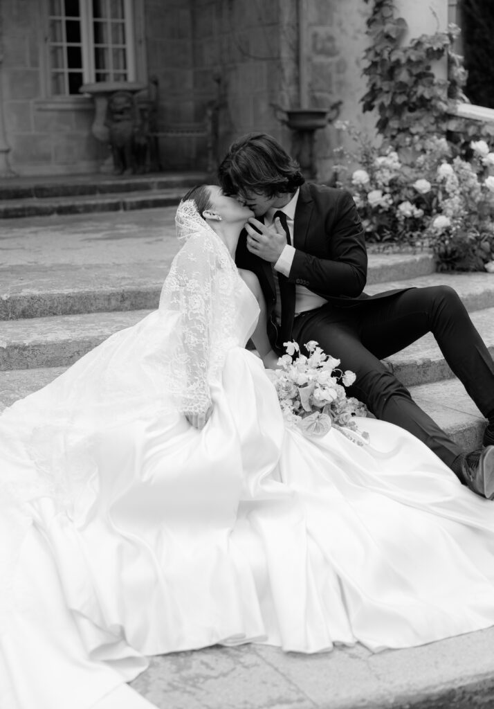 Black and white portrait of bride and groom on stone steps during a Spring La Caille wedding
