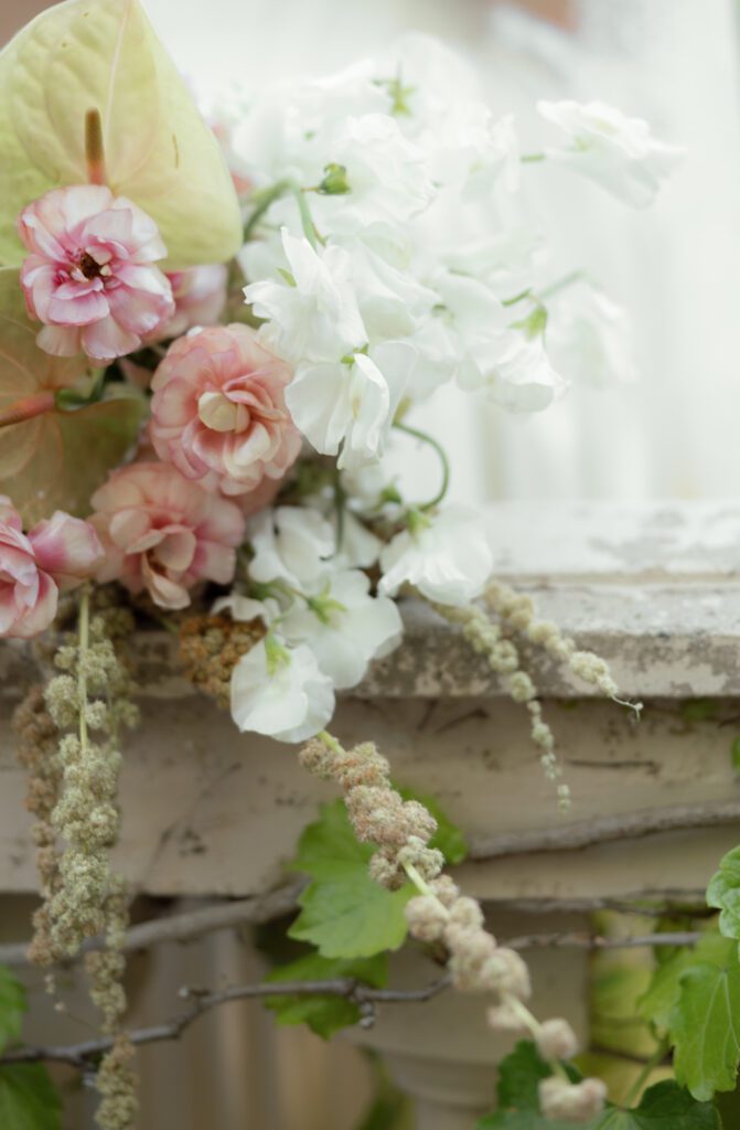 Soft spring florals by Flora and Fern Co on stone ledge at La Caille wedding venue