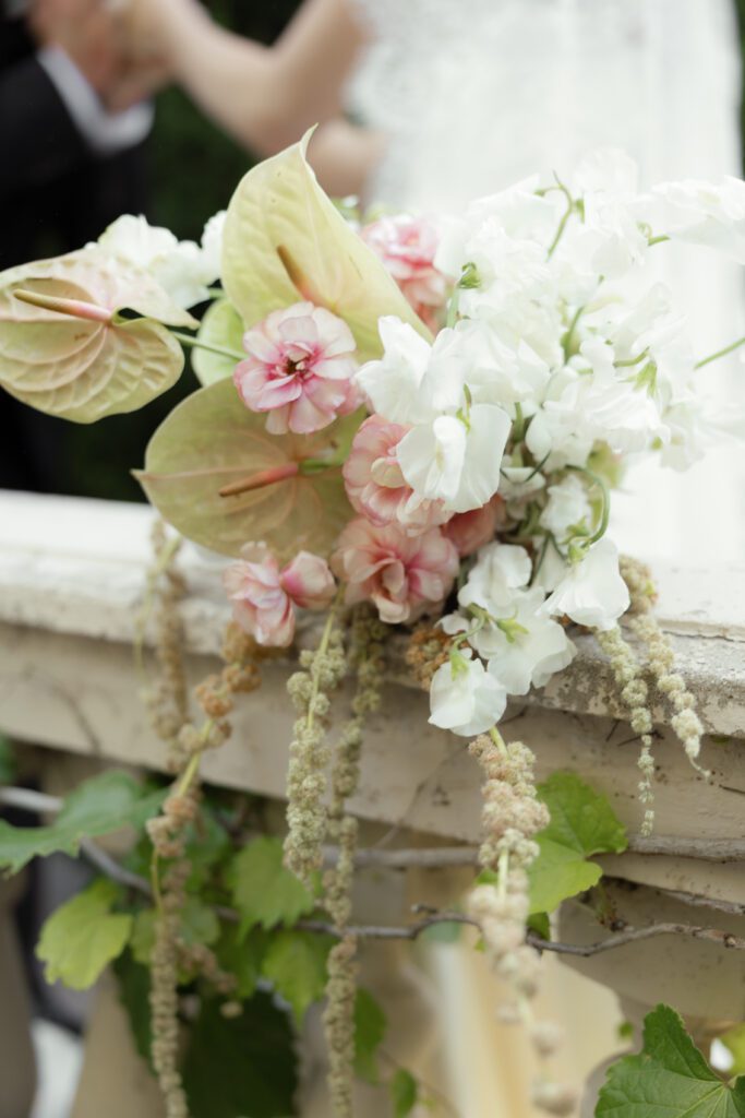 An organic wedding bouquet sitting on a pillar at the chateau at la caille in utah