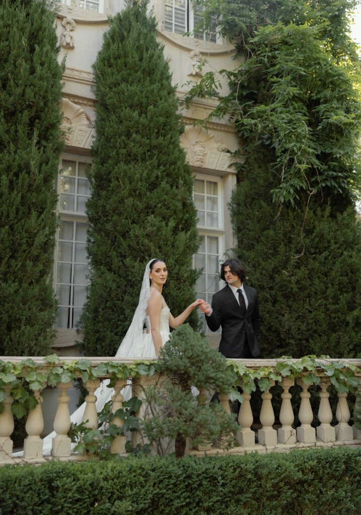 A bride and groom walking along the balcony of the chateau at la caille wedding venue in utah