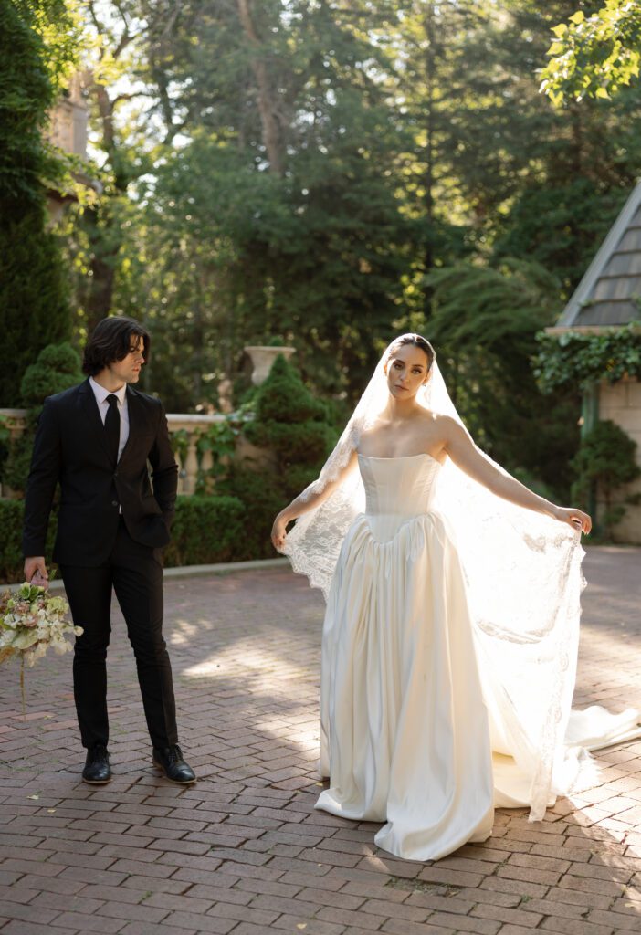 Bride in Basque waist gown with groom in soft morning light at La Caille in Utah