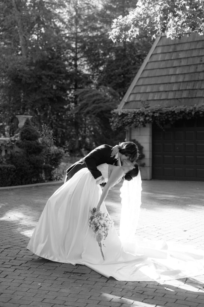 Groom dips bride and kisser her at a spring wedding at la caille