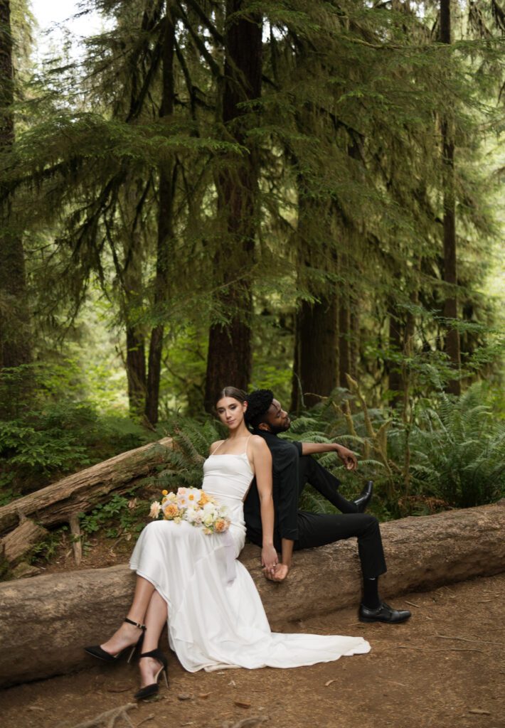 Bride and groom posing in lush forest near Drift Creek Falls Suspension Bridge during an Oregon elopement