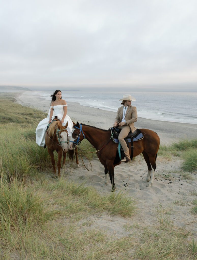 Bride and groom on horseback in the coastal dunes at Bob Straub State Park in Pacific City, Oregon