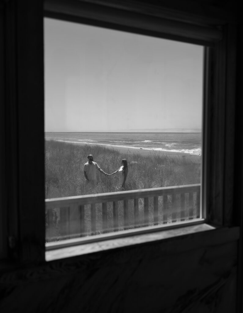 Bride and groom seen through a window at Our Plaace Airbnb in Neskowin, Oregon during an intimate wedding
