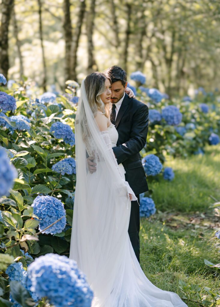 Bride and groom embracing in a hydrangea garden at The Hydrangea Ranch in Tillamook on the Oregon Coast