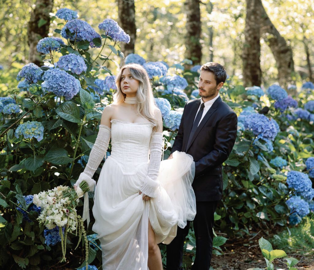 Bride and groom walking through blue hydrangeas at The Hydrangea Ranch in Tillamook, Oregon during an intimate wedding