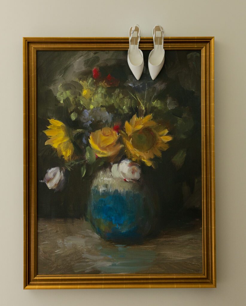 White bridal shoes displayed above a floral painting inside the Chateau at La Caille