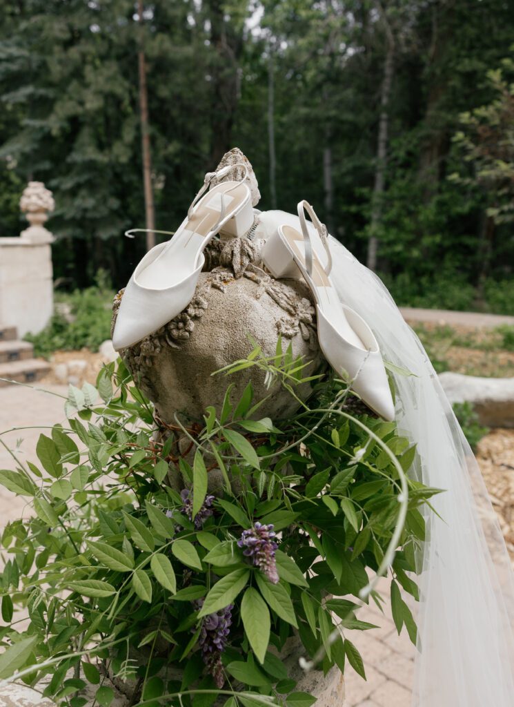 White bridal shoes and veil photographed in the gardens at La Caille Utah