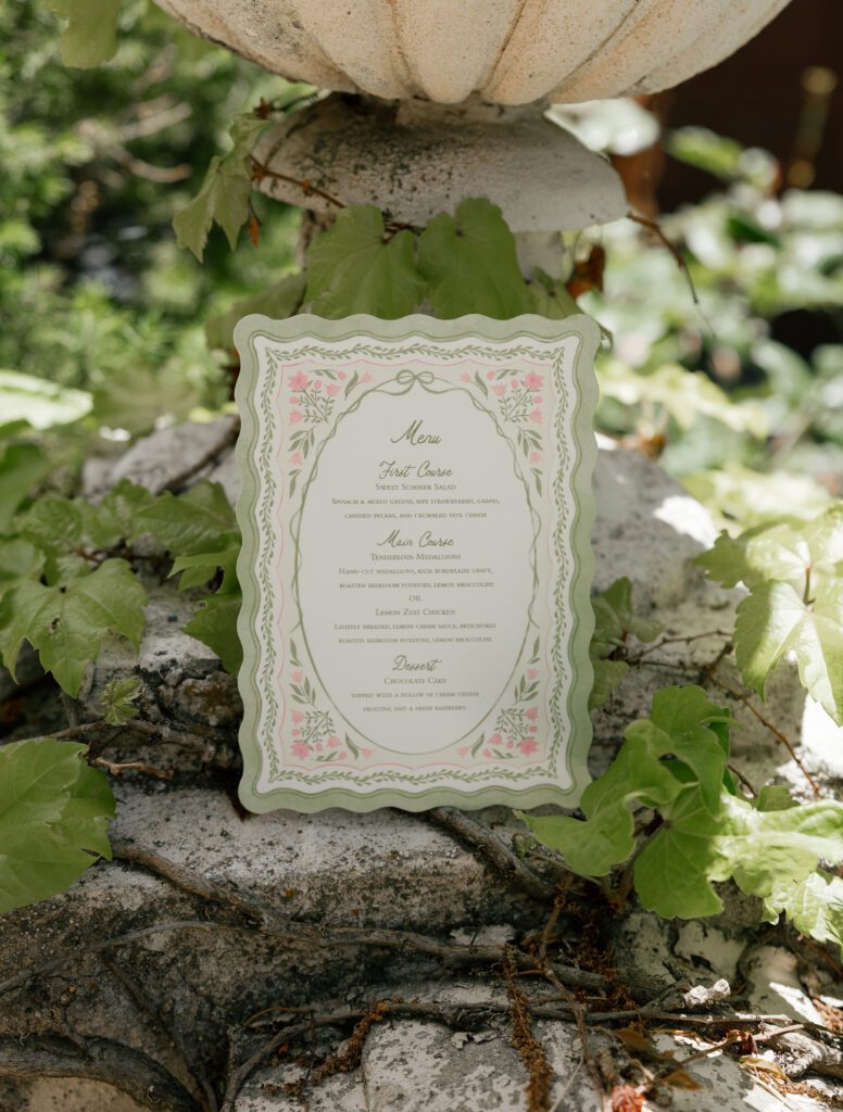 Floral wedding dinner menu photographed in the gardens at La Caille Utah