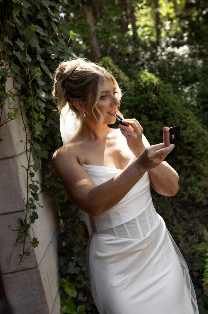 Bride puts on lipstick at La Caille Utah