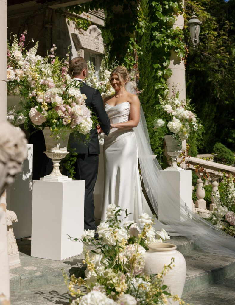 A bride and groom hold hands during their ceremony at la caille utah 