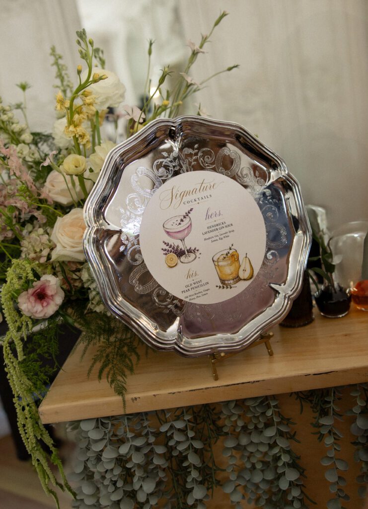 Signature cocktail menu surrounded by florals at a La Caille Utah wedding
