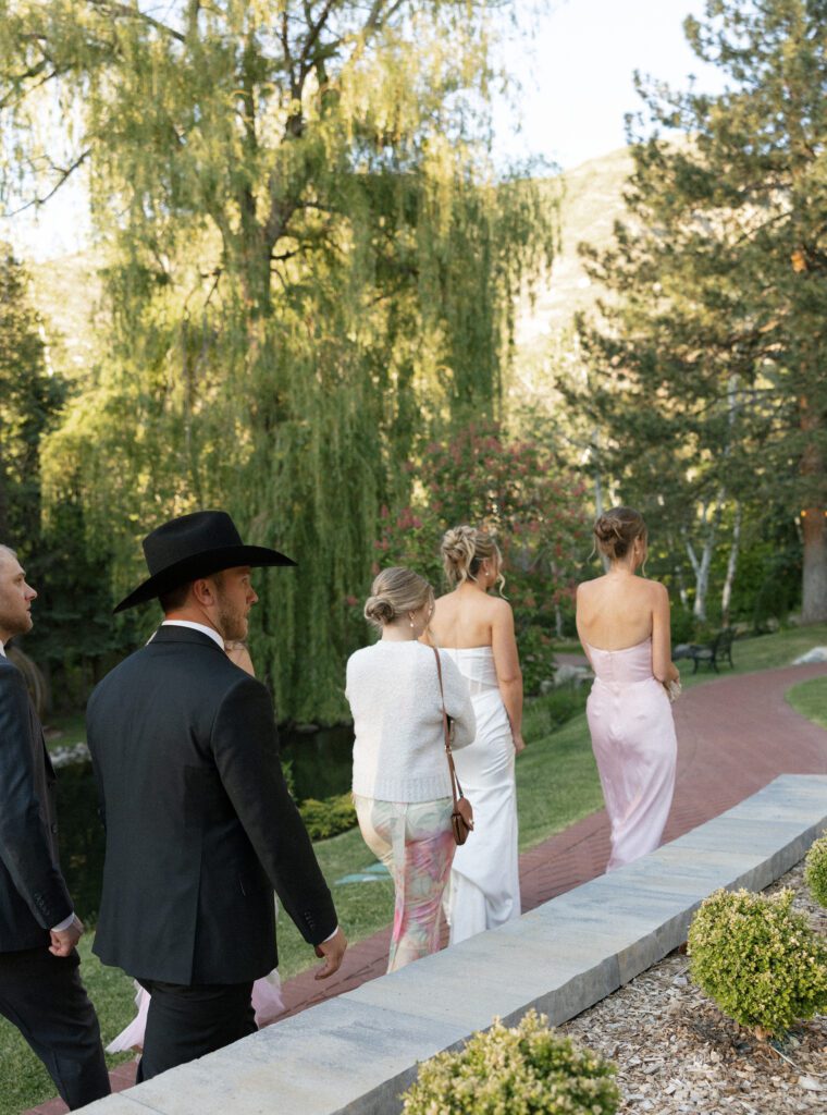 Wedding guests walking through the gardens at la caille utah 