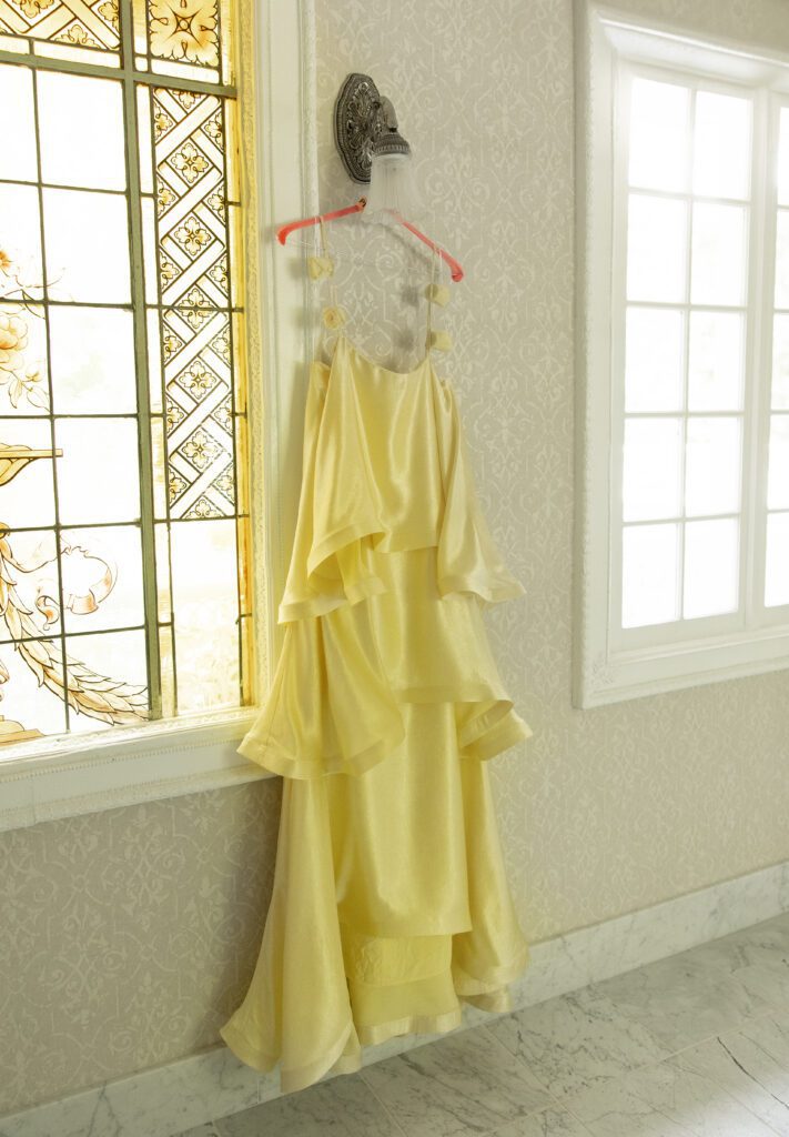 Yellow bridesmaid dress hanging in a window at La Caille Utah